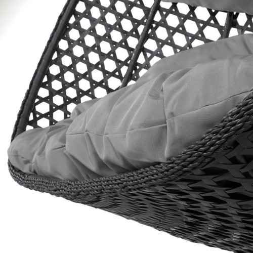 Wewnątrz kosza znajduje się gruba, miękka poduszka w jasnym, szarym kolorze, zapewniająca komfort użytkowania. Zbliżenie ukazuje teksturę materiałów – gładkość tkaniny poduszki oraz charakterystyczne sploty technorattanu.