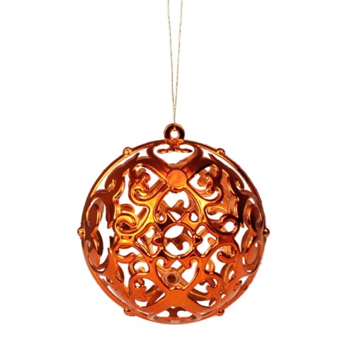 Bombka pomarańczowa z wyciętą strukturą z symetrycznymi wzorami przypominające np. koronkę.