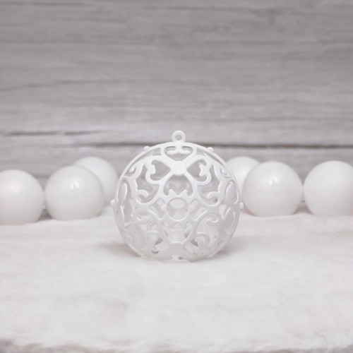 Zestaw zawiera bombki białe z wyciętą strukturą z symetrycznymi wzorami przypominające np. koronkę.
