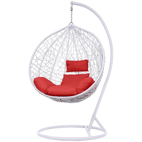 Fotel wiszący składa się z plecionego kosza w białym kolorze, zawieszonego na metalowym stelażu z zakrzywioną nogą i okrągłą podstawą oraz miękkich, czerwonych poduszek, zapewniających komfort siedzenia.