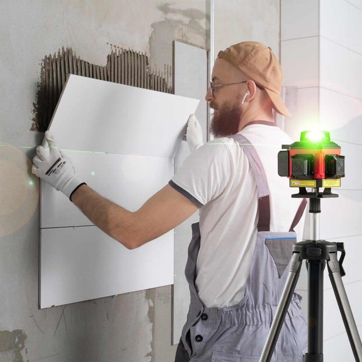 Poziomica laserowa w użyciu podczas prac remontowych, podczas gdy osoba układa płytki ceramiczne, używając lasera do wyznaczenia linii. 