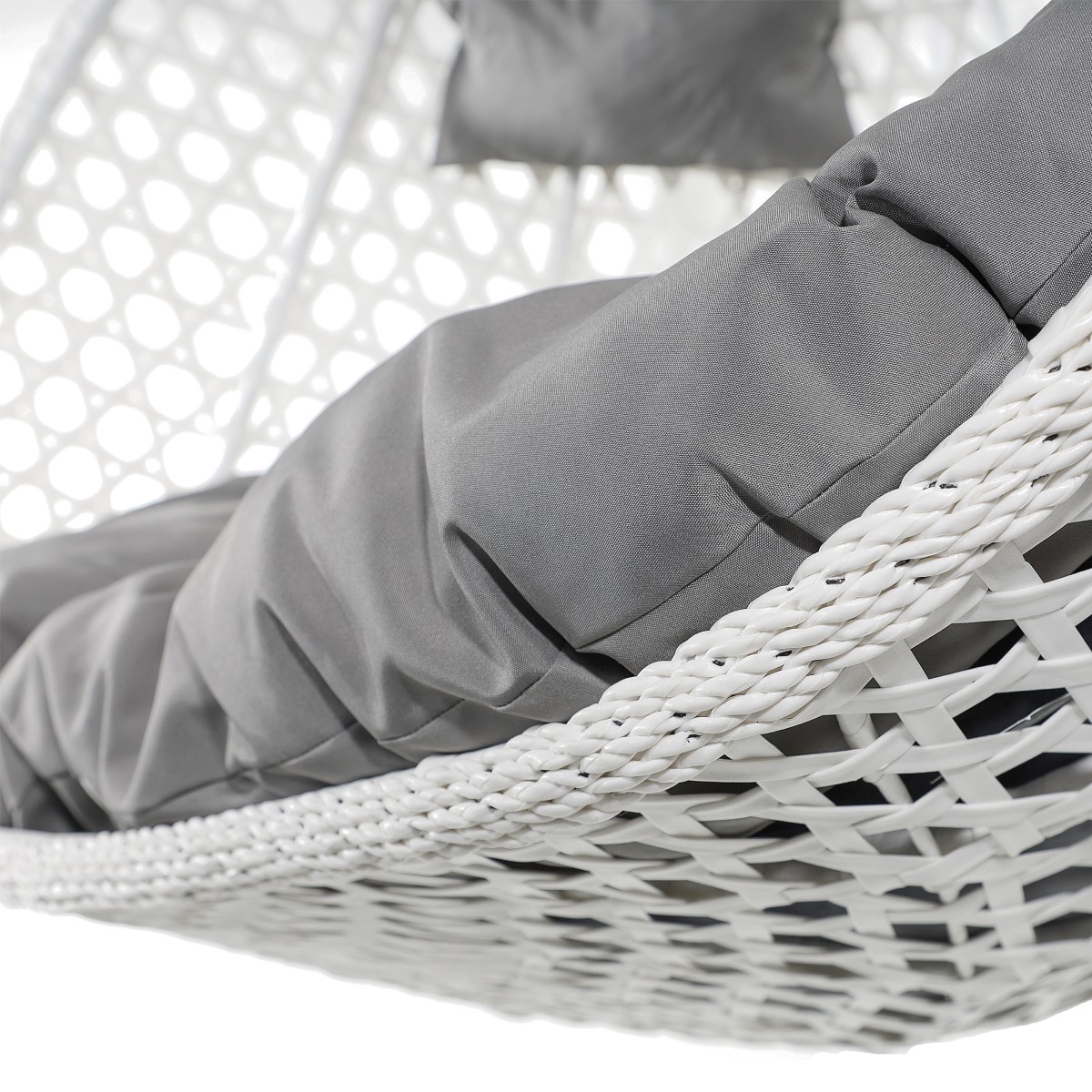 Wewnątrz kosza znajduje się gruba, miękka poduszka w jasnym, szarym kolorze, zapewniająca komfort użytkowania. Zbliżenie ukazuje teksturę materiałów – gładkość tkaniny poduszki oraz charakterystyczne sploty technorattanu.