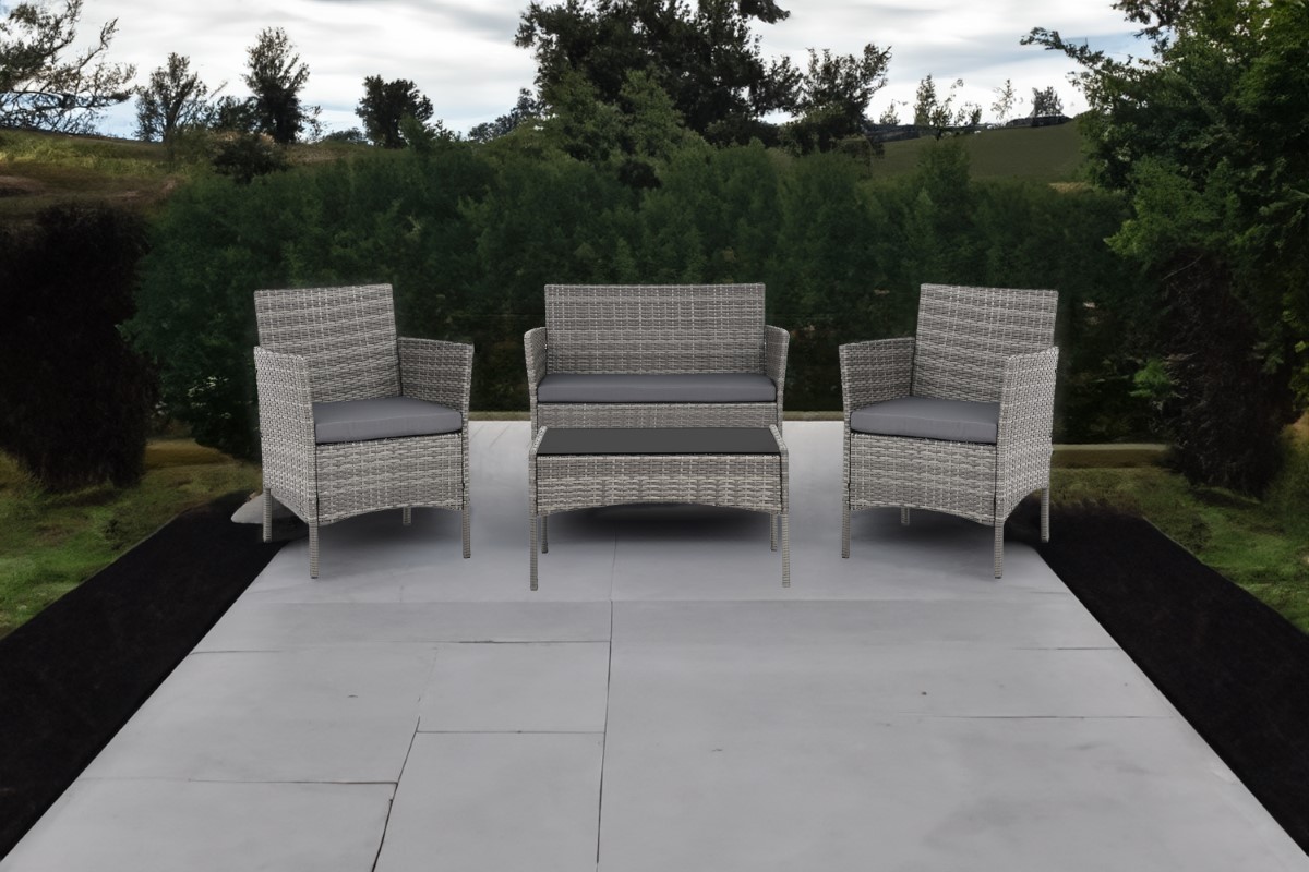 Komplet mebli Madera składający się z dwuosobowej sofy, dwóch foteli oraz stolika z blatem z hartowanego szkła, na tarasie.  