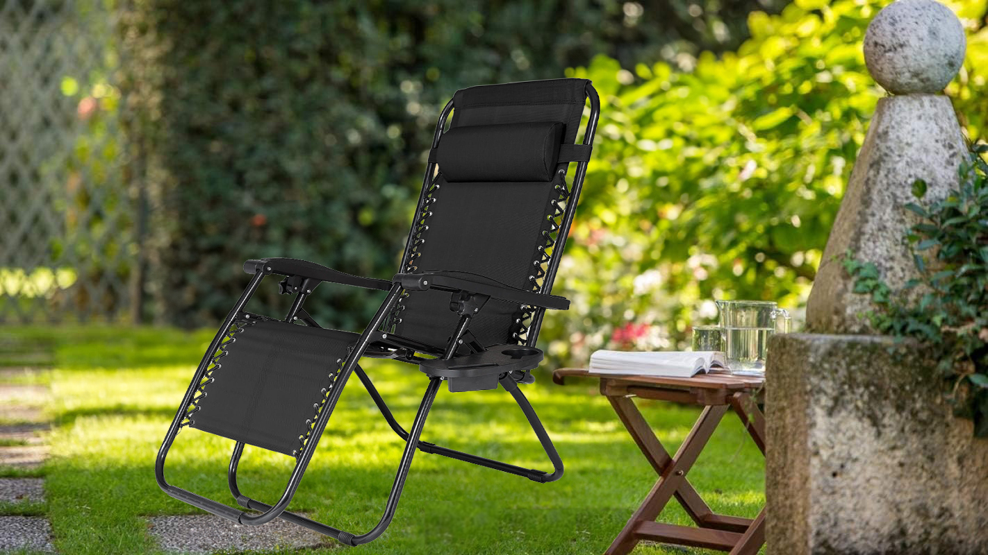Czarny leżak NO GRAVITY w pozycji siedzącej na tle ogrodu. 