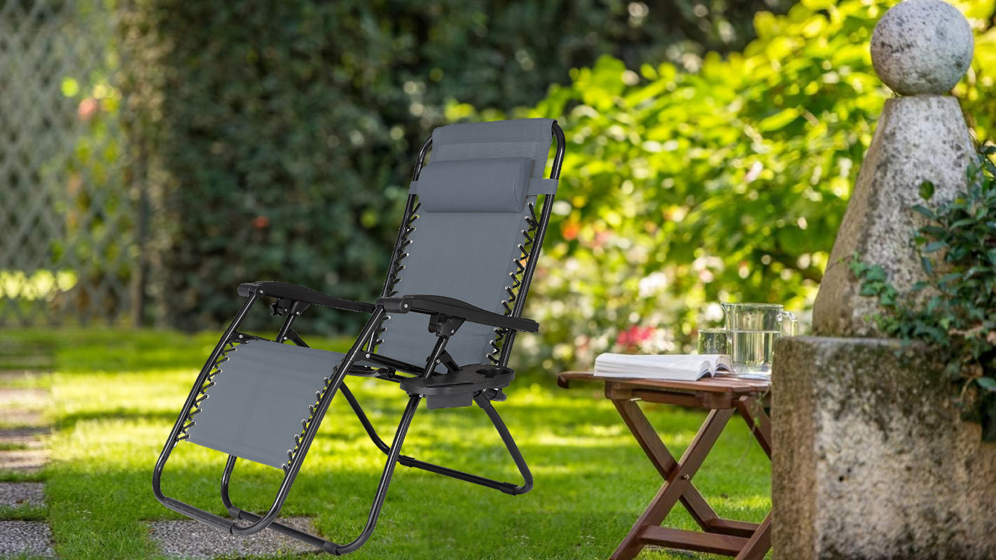 Szaro-czarny leżak NO GRAVITY w pozycji leżącej na tle ogrodu.